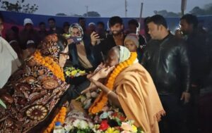 A request to “pass and look after them—that is, the Hindus”: Bimala Sarker presents a garland and money to Rumin Farhana